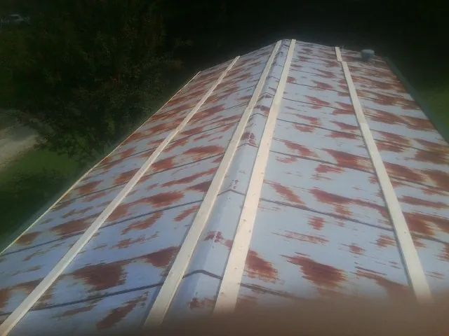 Rusted metal roof panels with new wood purlins before replacement — Storm Damage Roof Repair in Lebo by Roofing Brothers