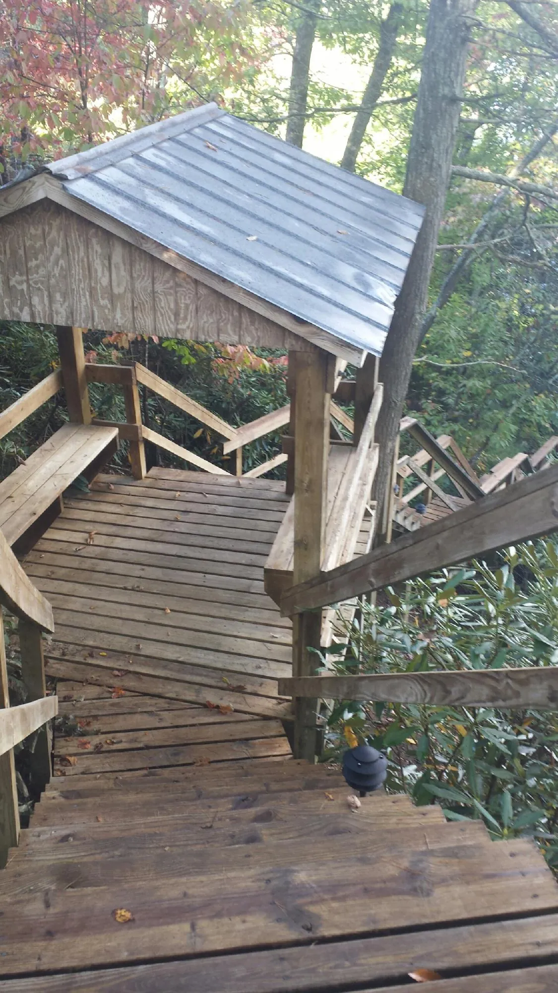 Metal roofed shelter over wooden steps on a wooded walkway — Skylight Repair & Installation work by our crew in Lebo
